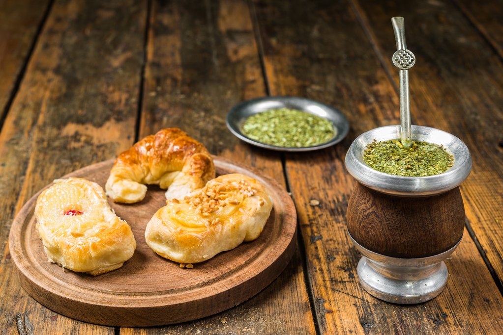 Traditional Argentinian yerba mate tea in calabash gourd and argentine pastries