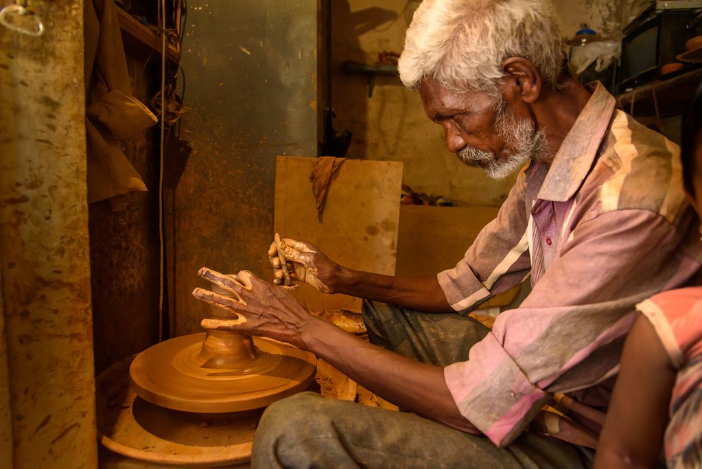 Indian potter making clay pots on pottery wheel in Pottery town is old place of Bangalore