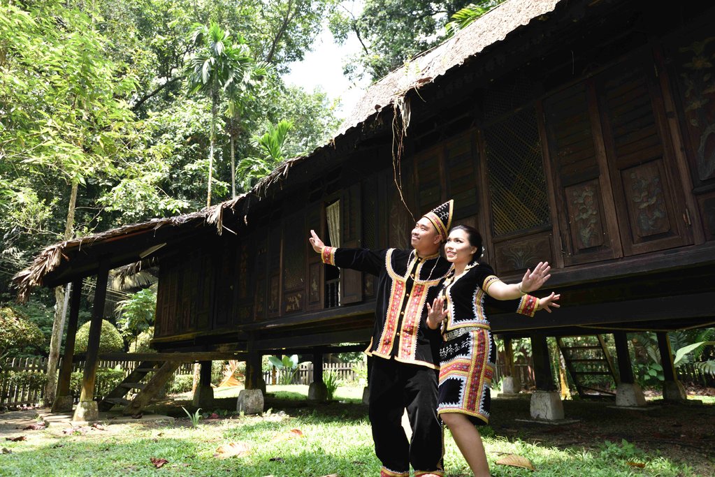 A couple dancing outside their longhouse