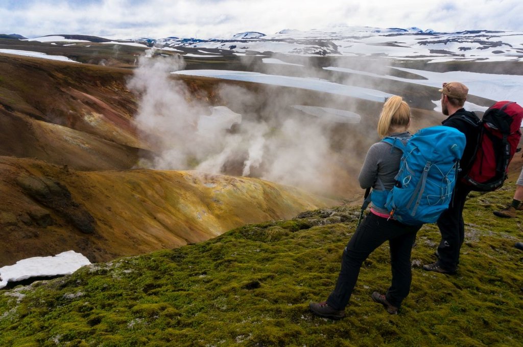 Watch steam rising from hot springs next to snow-covered hills
