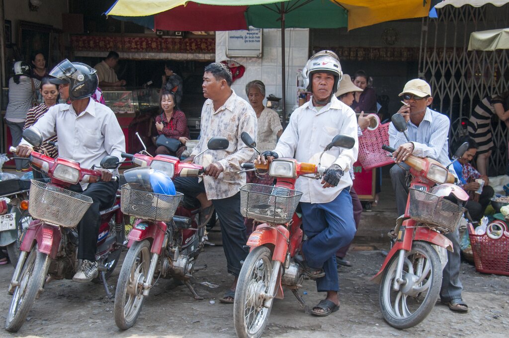Motorcycle taxi drivers outside a market