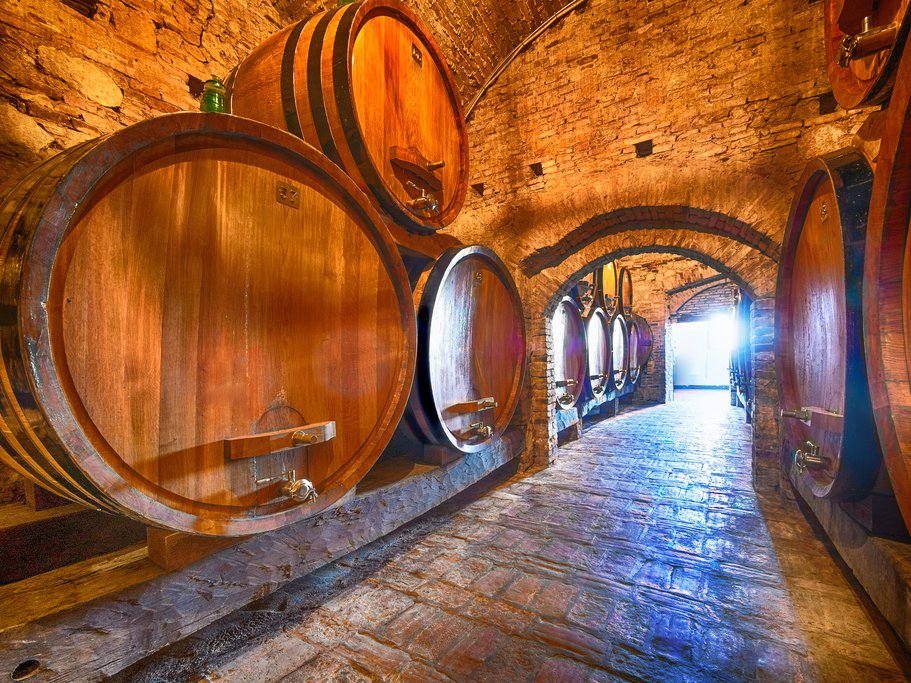 Barrels of wine aging in a Barolo vineyard