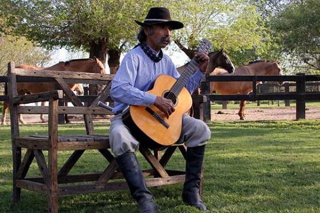 An Argentine gaucho strumming a tune on his guitar.