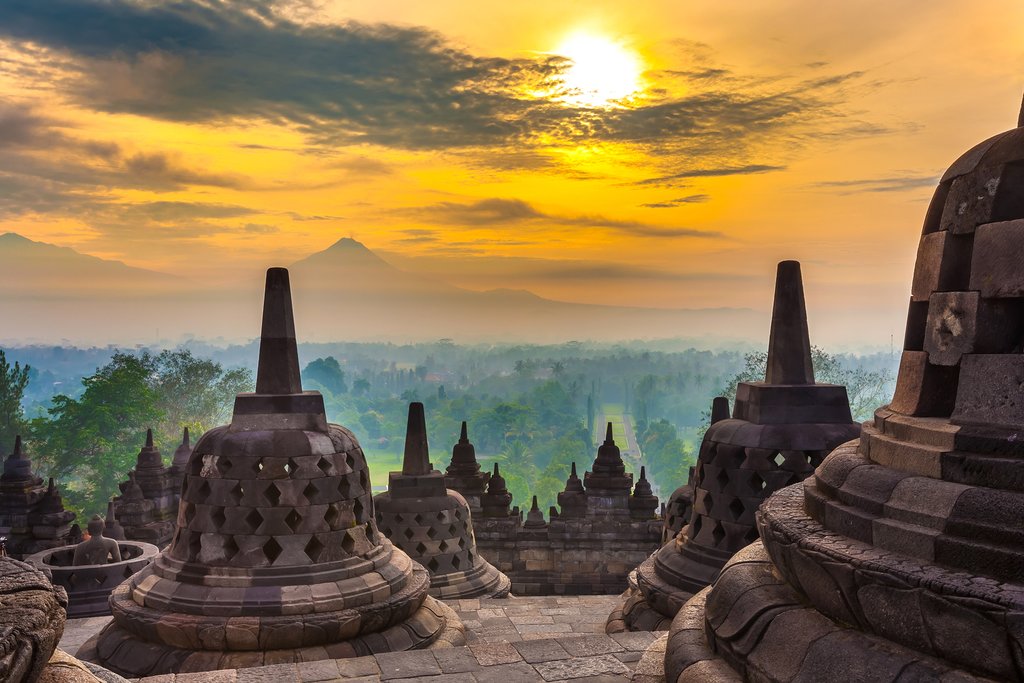 Taman Lumbini park from the height of the temple complex Candi Borobudur at sunrise in the fog. Candi Borobudur, Yogyakarta, Jawa, Indonesia