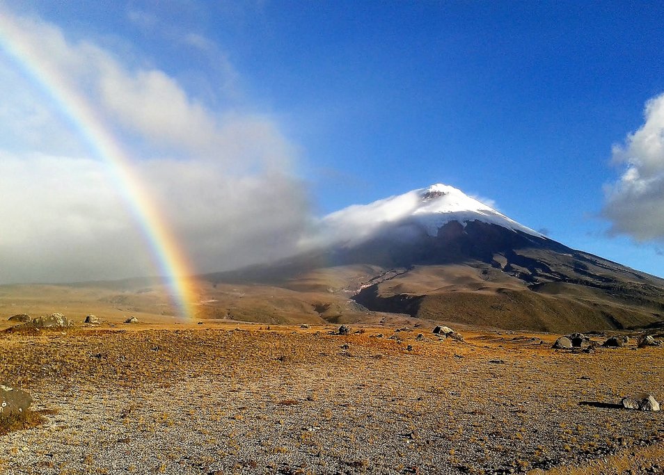 Two beautiful sights: a rainbow and Cotopaxi volcano