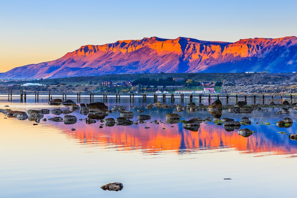 A gorgeous sunset reflects off the cliffs and water at Puerto Natales