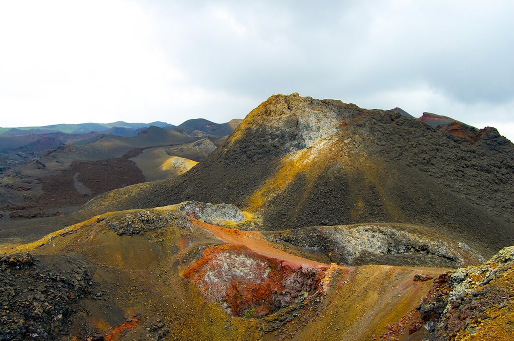 Red, orange, and brown dust and rocks within the Sierra Negra Volcano