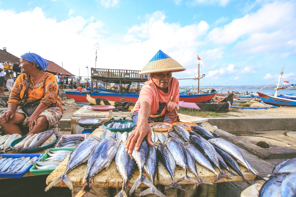 A man selling fish at a market on the beach in Bali