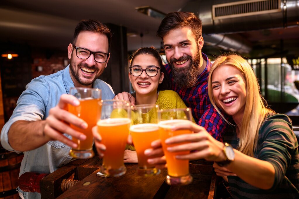 young people with pints of beers in hand