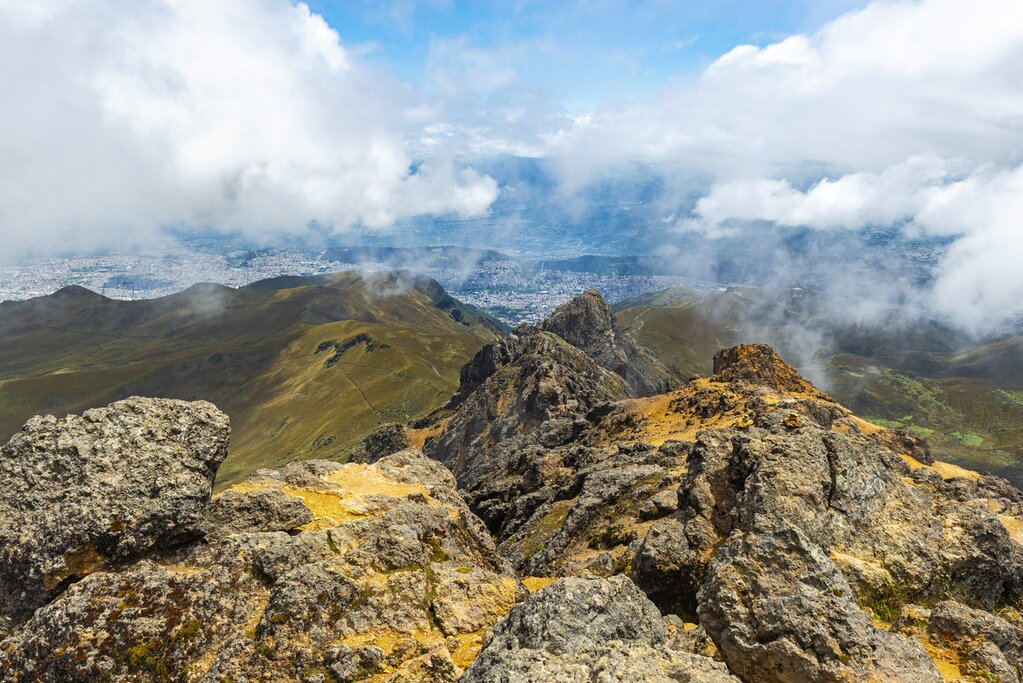 The peak of Rucu Pinchincha in Quito, Ecuador, with clouds and Quito in the background
