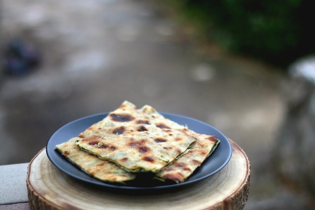 Plate of soparnik (a type of savory pie) with prosciuto and cheese