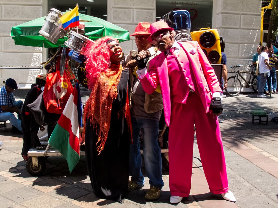 Group of people in bright clothes singing in the street