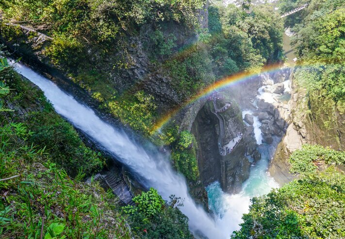 A rainbow over the Pailón del Diablo waterfall in Baños