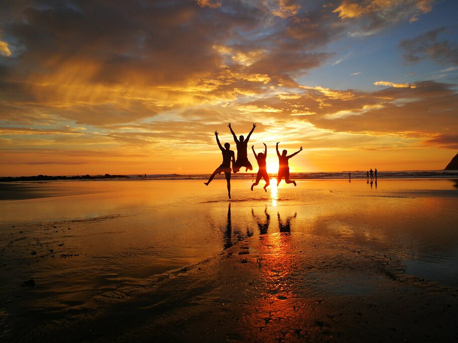 Family in mid-jump on Costa Rica beach at sunset - Photo by Adrian Eriksson on Unsplash