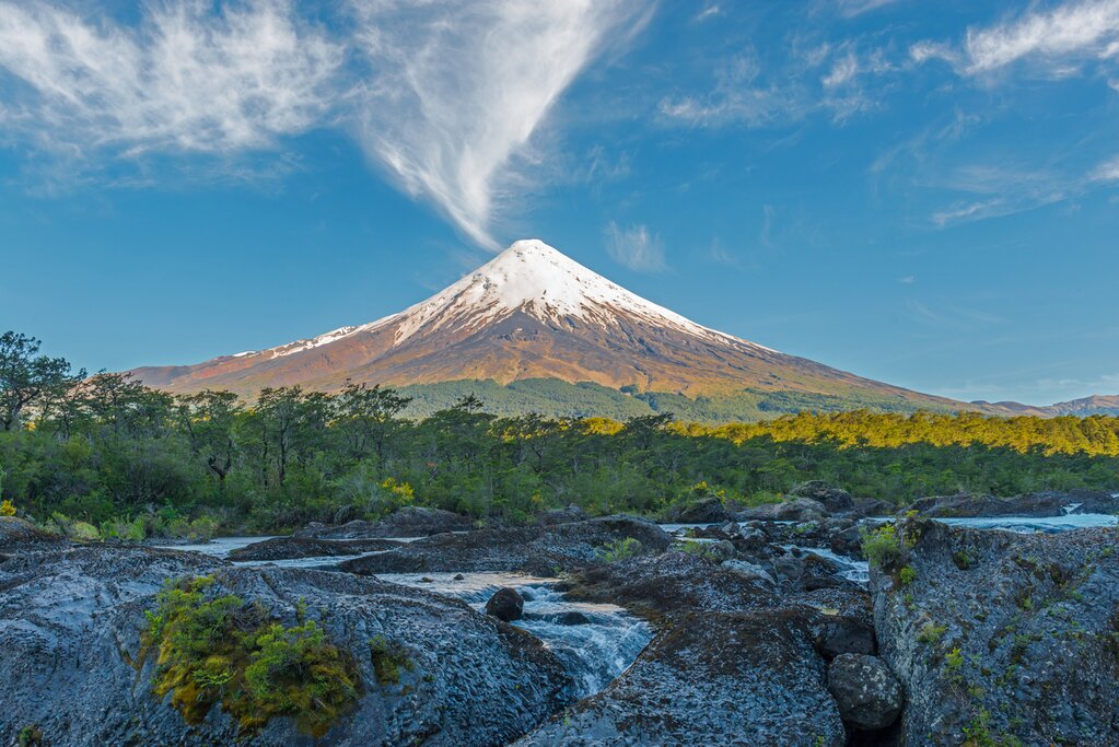 A landscape view of the Río Petrohué waterfalls with Orsorno Volcano in the background