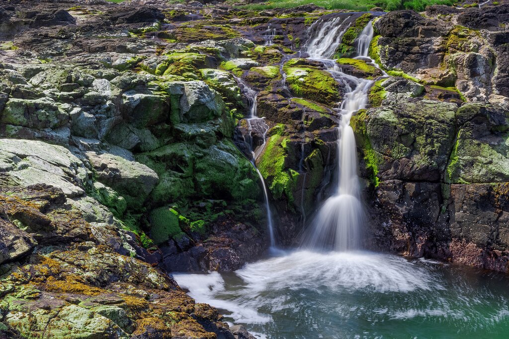 Dunseverick Falls running into the Atlantic Ocean