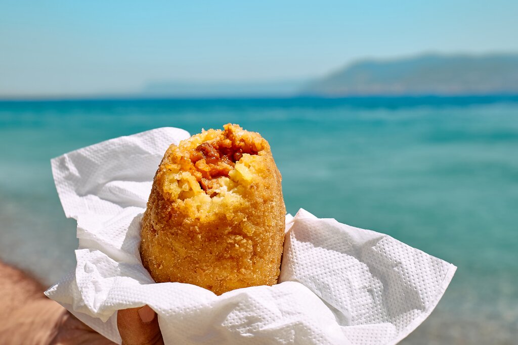 Savor arancini with a sea view in Sicily