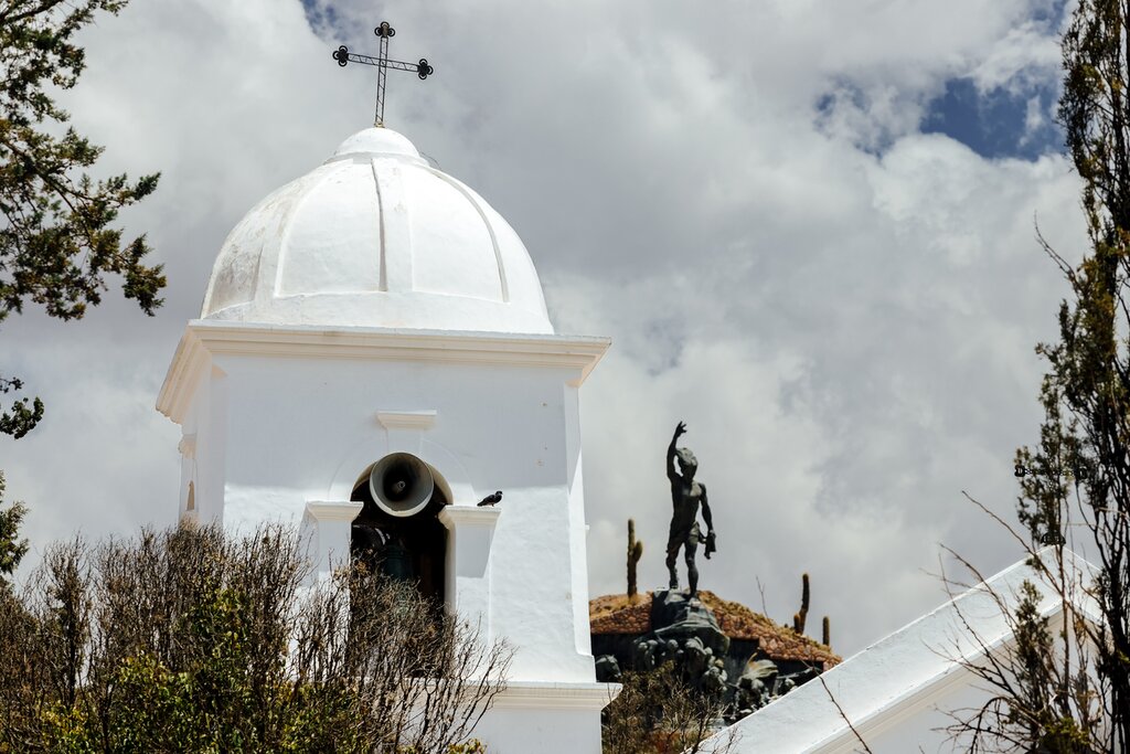 Close-up of bell tower with Monument to the Argentine Heroes of Independence in the background in Humahuaca