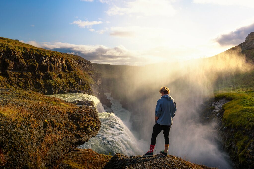 A hiker stands at Gullfoss