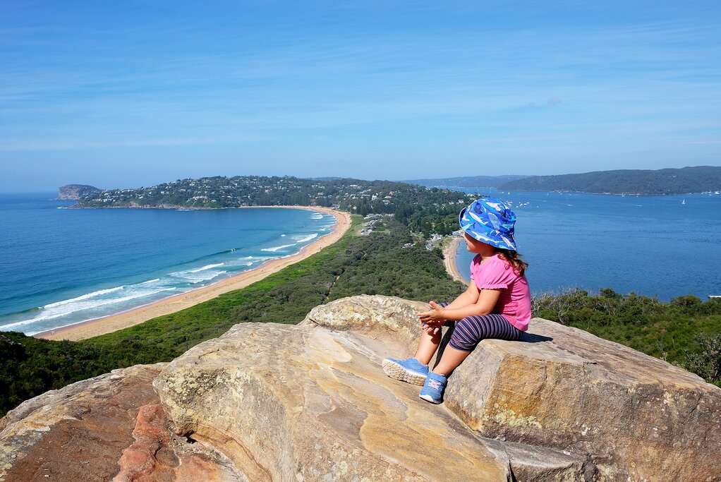A girl admires Palm Beach from atop a rock