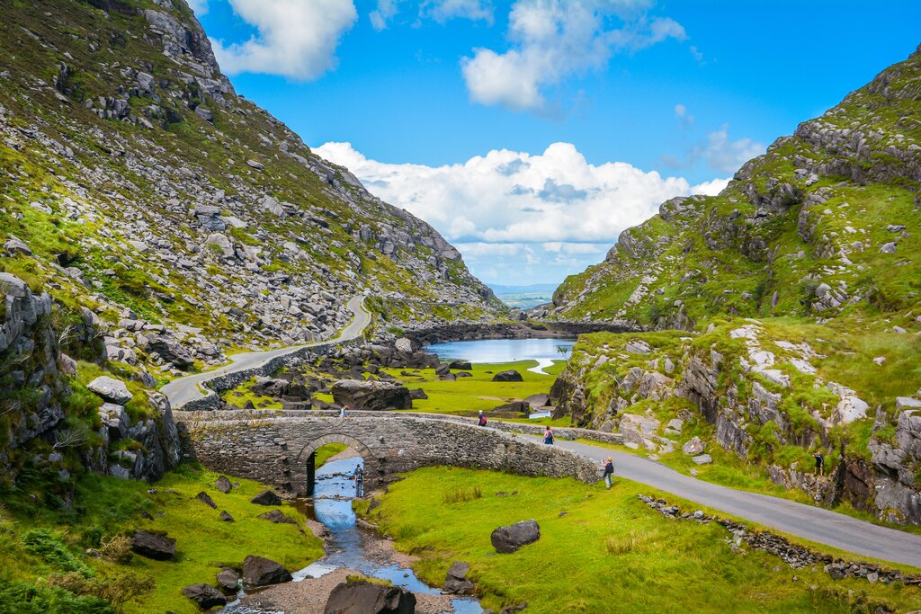 A tony stone bridge backed by lakes and mountains