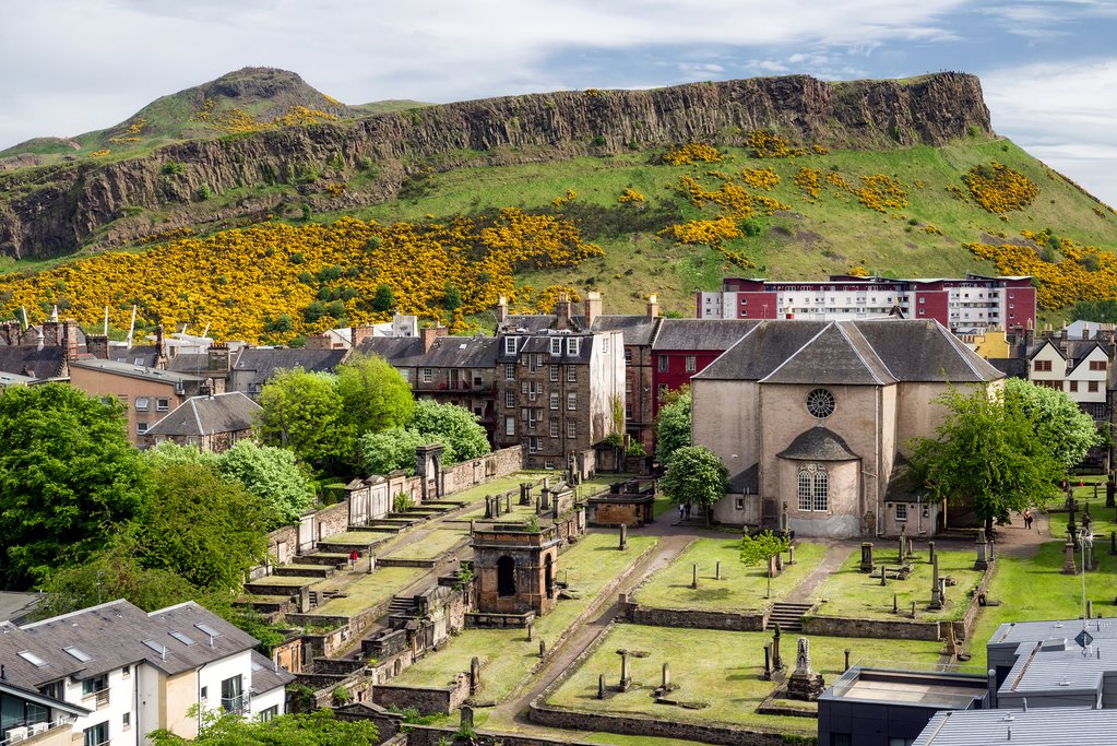 Salisbury crags over Edinburgh, Scotland. Church Canongate Kirk with graveyard