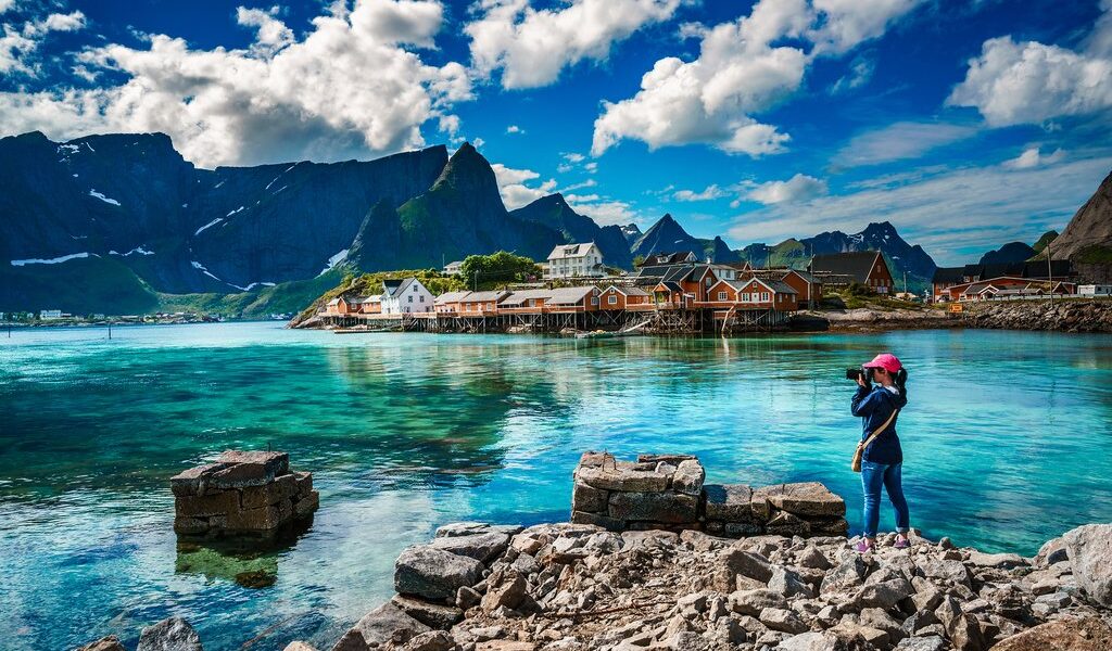 Nature photographer tourist with camera shoots Lofoten archipela
