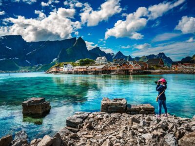 Nature photographer tourist with camera shoots Lofoten archipela