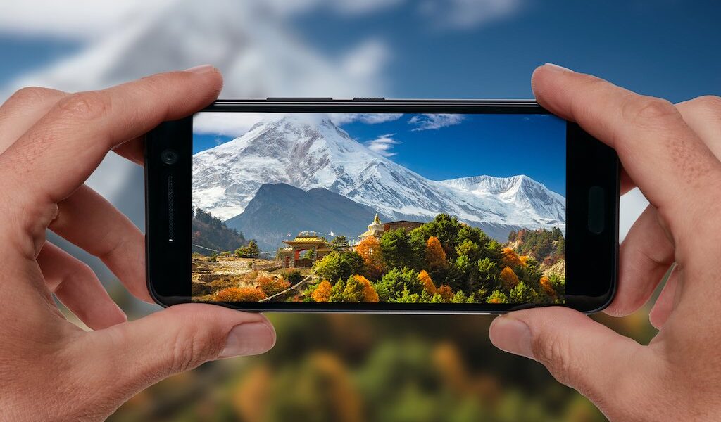 Travel concept. Tourist making photo of Himalayas mountain landscape. Buddhist monastery and Manaslu