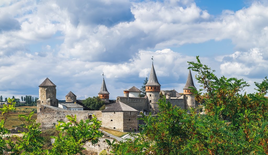 Old Kamianets-Podilskyi Castle under a cloudy blue sky, Ukraine