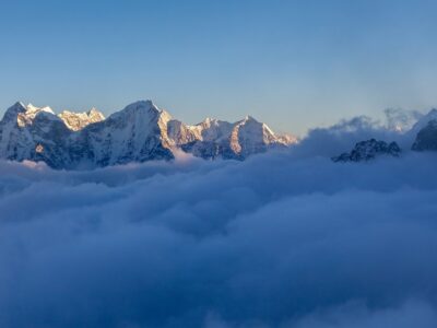 Picturesque Mountain Valley Filled With Curly Clouds At Sunset.