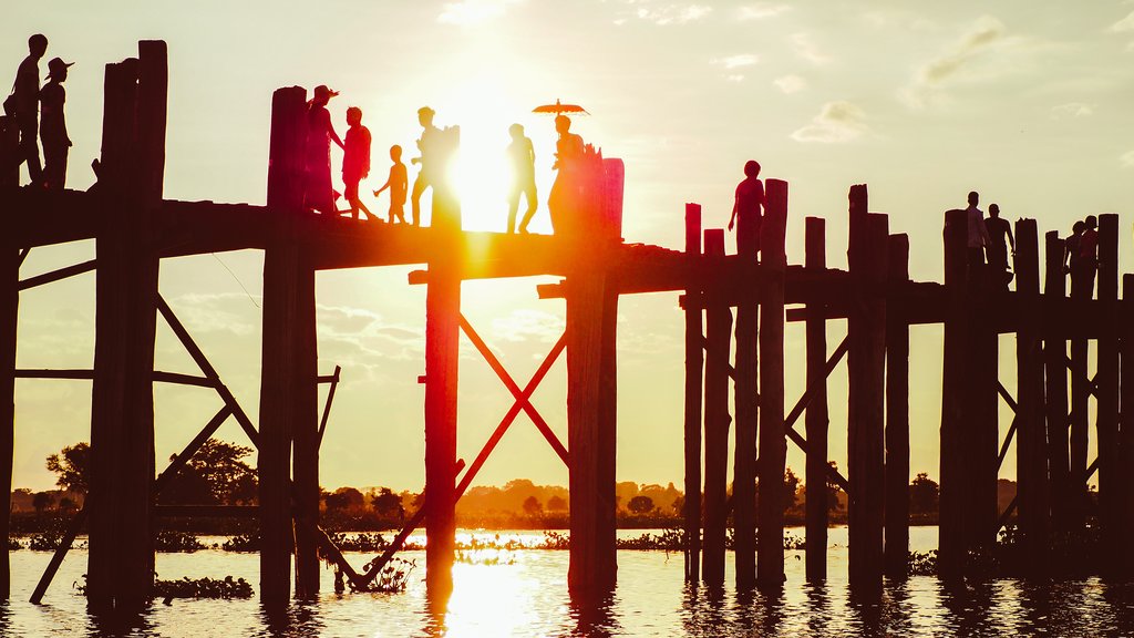 Silhouettes of people walking on the U-Bein bridge in the evening in Amarapura
