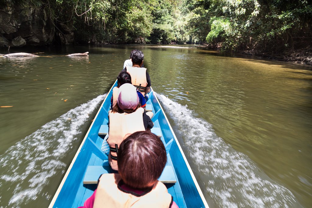 Riding long boat on Merlinau river to Wind and Clear Water caves