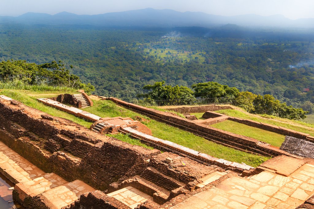 From the top of Sigiriya Rock Fortress, enjoy a view of the surrounding hills and elegantly terraced fortress floor