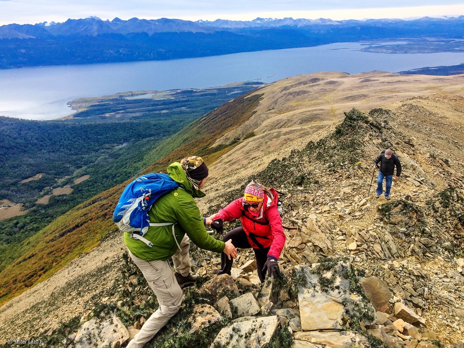 Trekkers helping each other on a craggy section of trail