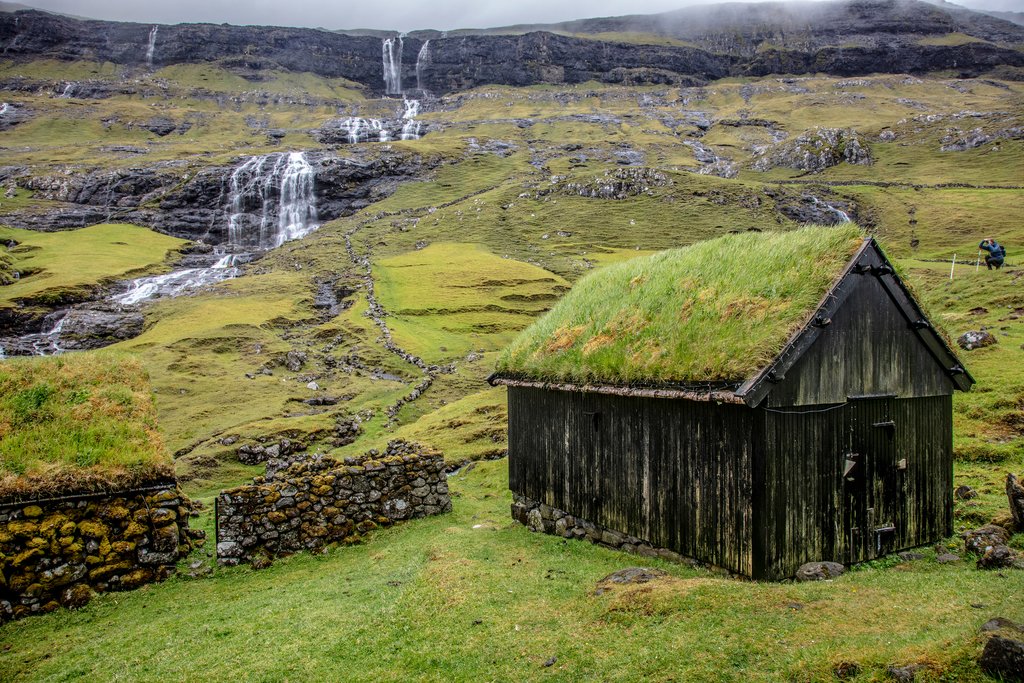 A sod roof house and waterfalls in Saksun