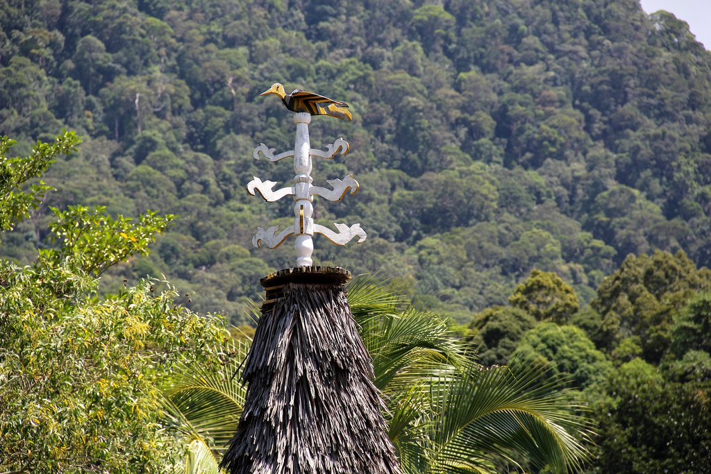 Wooden hornbill on top of a traditional Bidayuh house