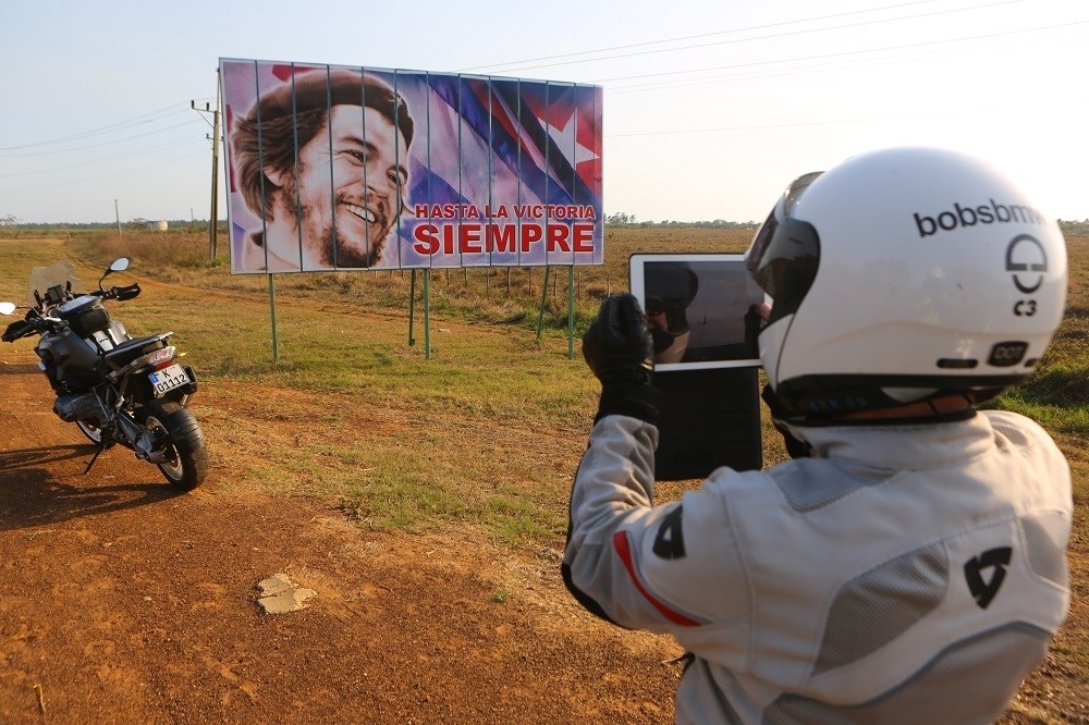 US motorcycle tour member photographs a Che Guevara billboard, Cuba; ; copyright Christopher P Baker. All rights reserved.