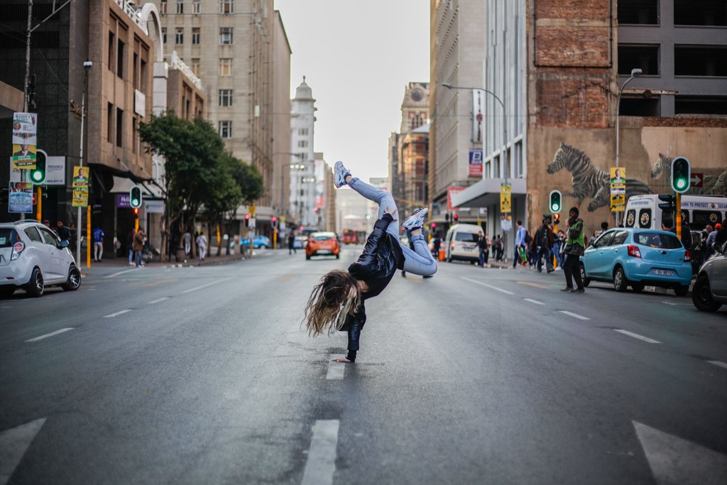 A woman does a handstand in a Johannesburg street