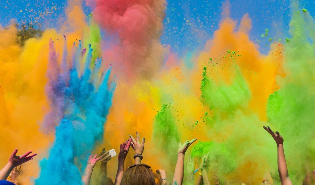 crowd of people throwing colored paint on Holi festival