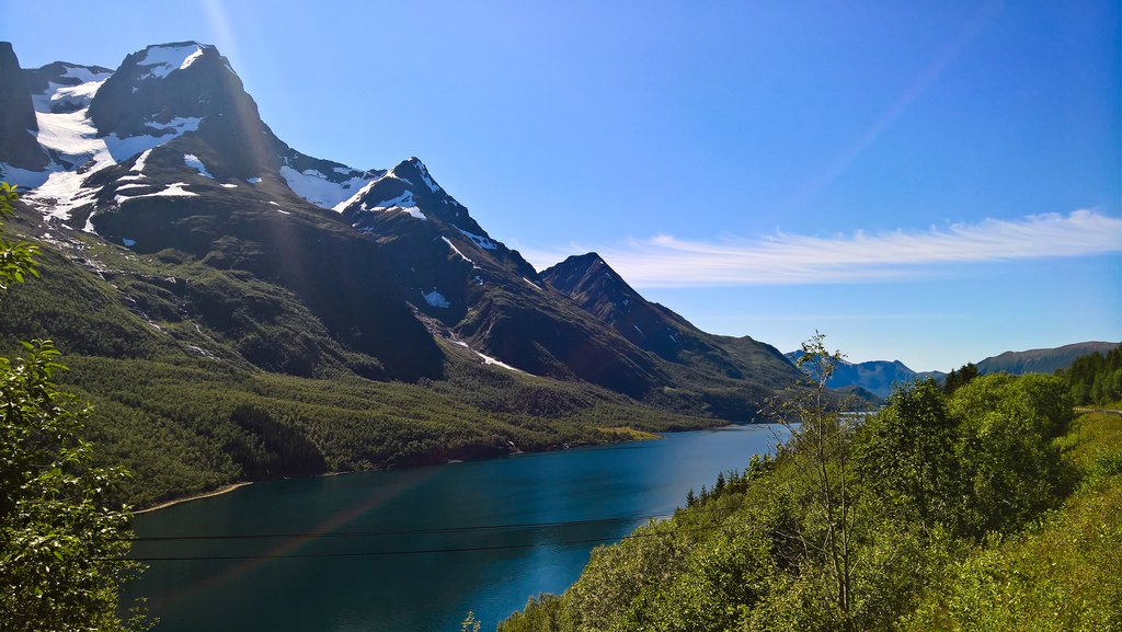 Snowy mountains shine bright in the summer sun.