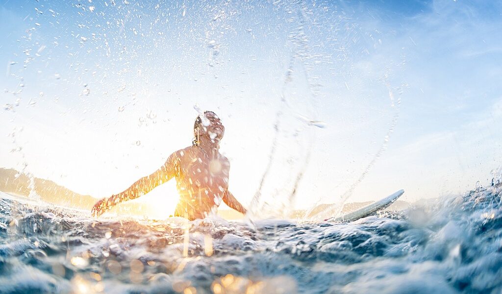 Surfer haves fun and makes water splashes being on line up durin