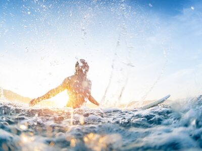 Surfer haves fun and makes water splashes being on line up durin