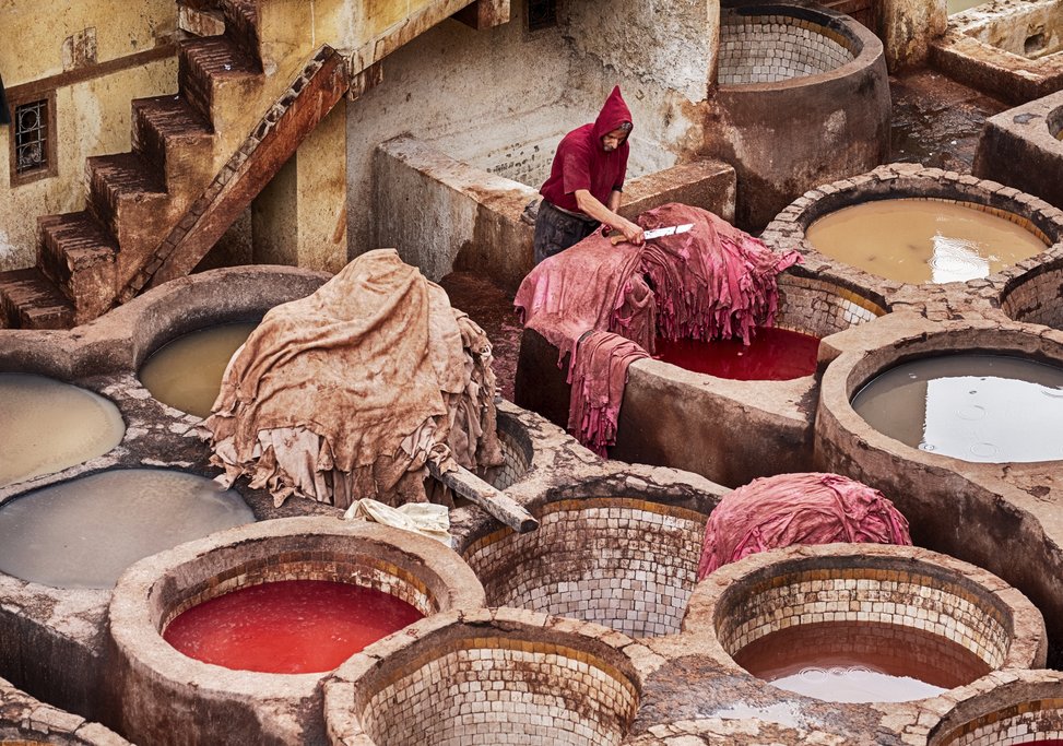 A worker trims a pile of leather hides in the Fes tannery