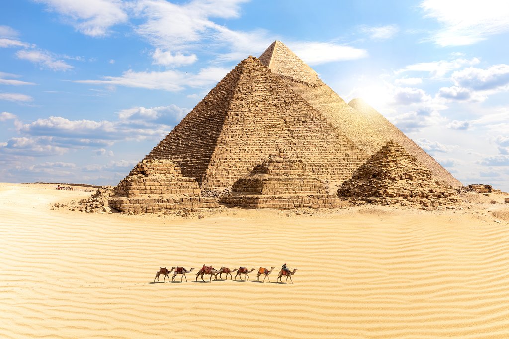 Egypt - Cairo - Great Pyramids of Giza and train of camels in foreground