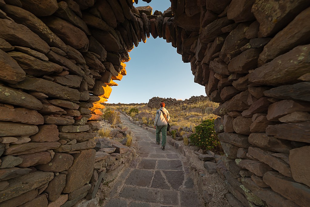Traveler exploring Inca trails at sunset on Amantani Island