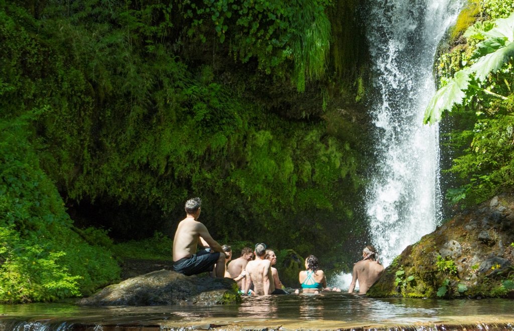 A dip beneath a waterfall in Geométricas hot springs