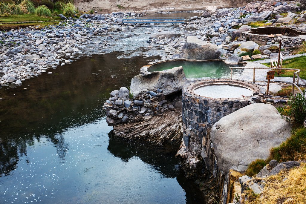 Relax in the hot mineral waters of the crystalline hot springs as the cold mountain river rushes by below you