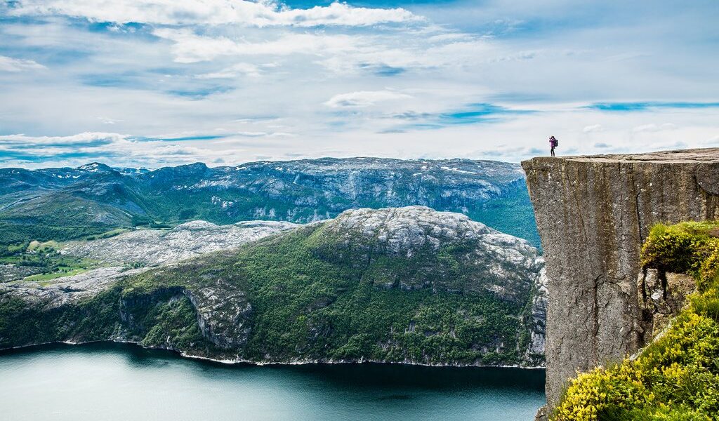 Nature photographer tourist with camera shoots while standing on