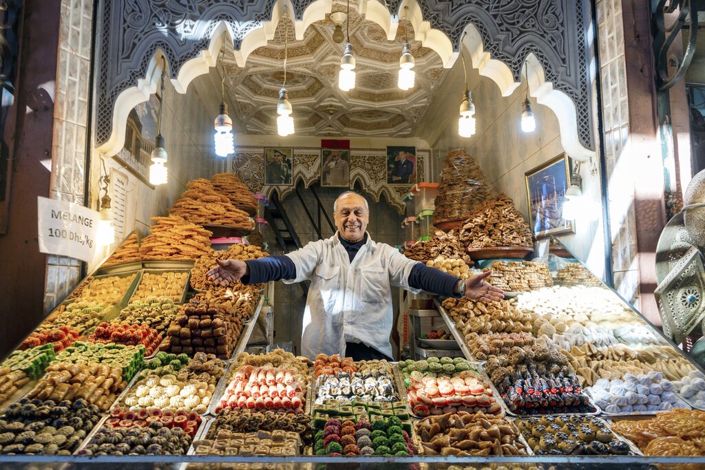 Man presenting his shop with delicious baklavas located in old town of Marrakech